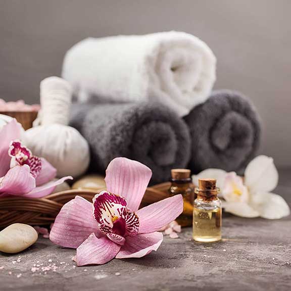 Pink orchid flowers, essential oils, white and grey towels